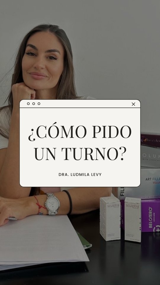 La Dra. Ludmila Levy sonríe apoyada en su escritorio, con la mano bajo el mentón